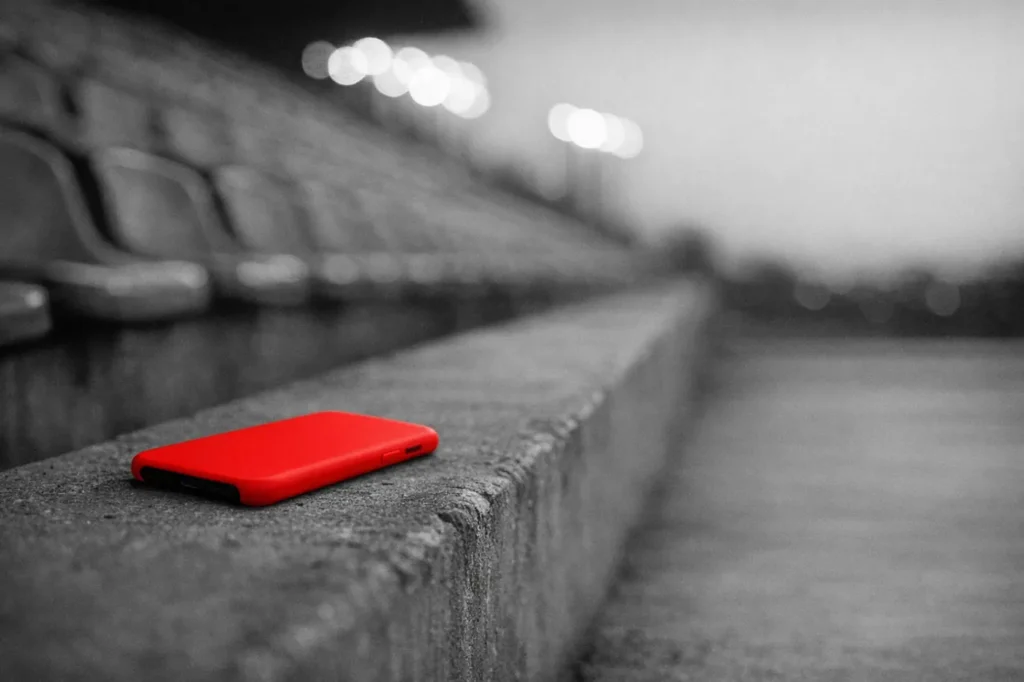 Betting apps: a smartphone in a red case lying on an empty stadium terrace