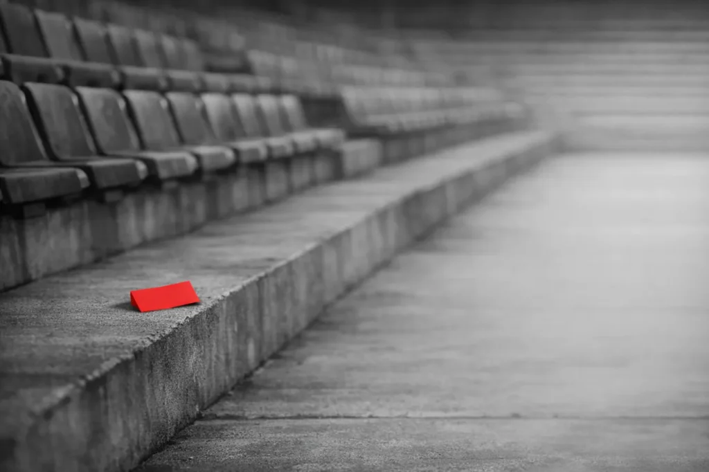 Betting sign up offers: a red paper ticket on an empty stadium terrace step